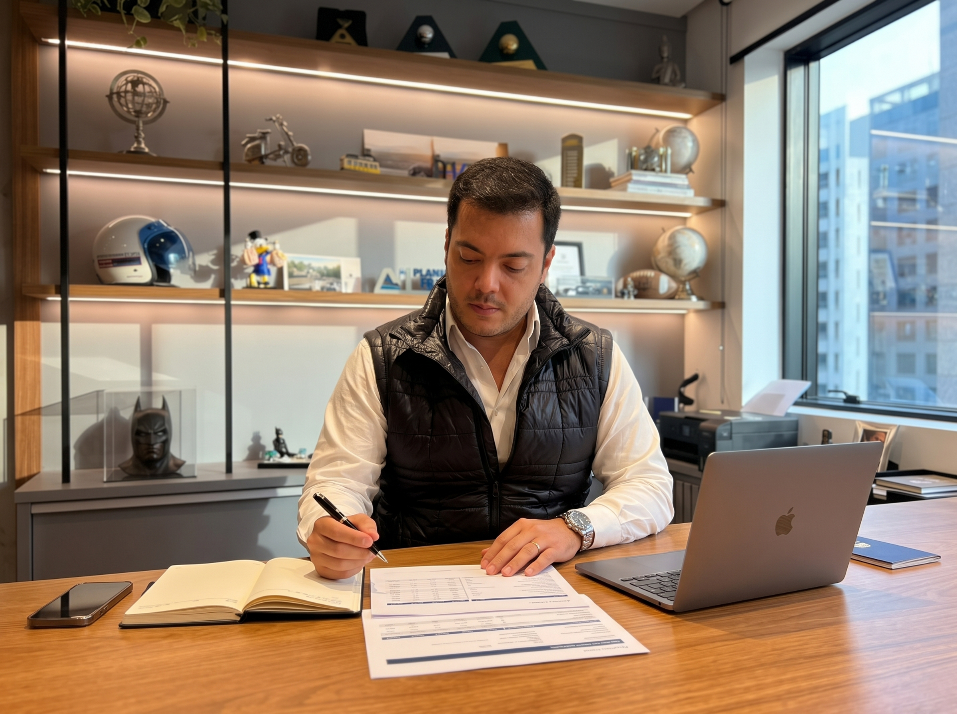 Abel Triboni em seu escritório trabalhando em análise financeira sobre a mesa